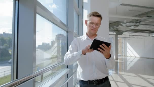 Bir tablet ile bir pencerede olgun iş adamı — Stok video