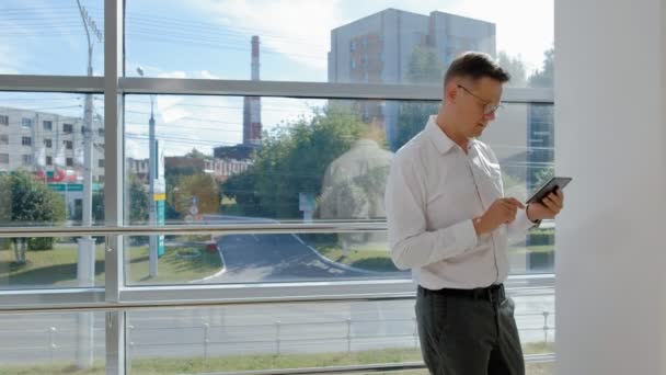 Homme d'affaires mature à une fenêtre avec une tablette — Video