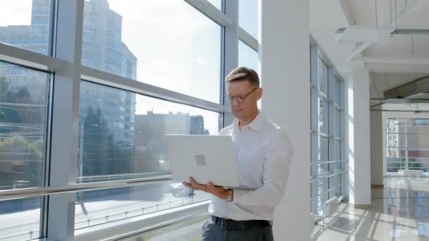 Homme d'affaires mature à une fenêtre avec un ordinateur portable — Video