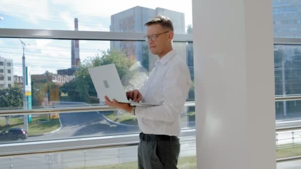 Rijpe zakenman in een venster met een laptop — Stockvideo