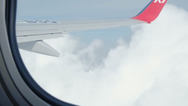 Vista del cielo azul y las nubes a través de la ventana de la aeronave, Primer plano Ventana del avión con ala de avión, Concepto de viaje . — Vídeos de Stock