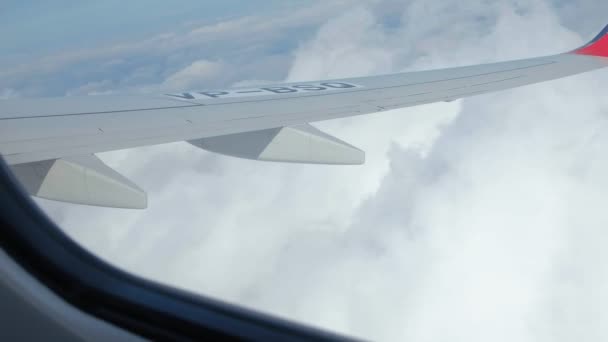 Vista del cielo blu e delle nuvole attraverso il finestrino dell'aereo, Close up Finestrino dell'aereo con ala dell'aereo, Concetto di viaggio . — Video Stock