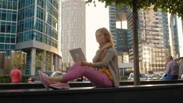 Jonge hipster vrouw is wandelen in het city park business center — Stockvideo