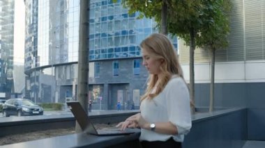 Şehir park iş merkezi içinde laptop üzerinde çalışan genç iş kadını