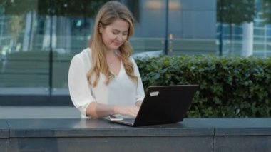 Şehir park iş merkezi içinde laptop üzerinde çalışan genç iş kadını