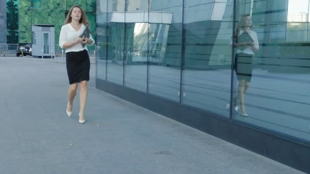 Joven mujer de negocios está paseando en el centro de negocios del parque de la ciudad — Vídeo de stock