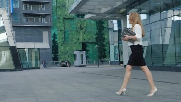 Joven mujer de negocios está paseando en el centro de negocios del parque de la ciudad — Vídeos de Stock