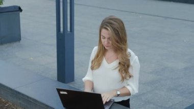 Şehir park iş merkezi içinde laptop üzerinde çalışan genç iş kadını