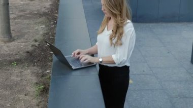 Şehir park iş merkezi içinde laptop üzerinde çalışan genç iş kadını