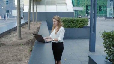 Şehir park iş merkezi içinde laptop üzerinde çalışan genç iş kadını