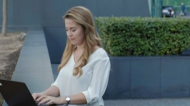 Şehir park iş merkezi içinde laptop üzerinde çalışan genç iş kadını