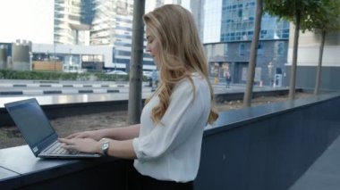 Şehir park iş merkezi içinde laptop üzerinde çalışan genç iş kadını