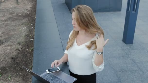 Şehir park iş merkezi içinde laptop üzerinde çalışan genç iş kadını — Stok video