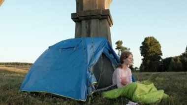 Bir dizüstü bilgisayar eski Köprüsü yakınlarında bir turist çadırda arkasında çalışan genç kadın