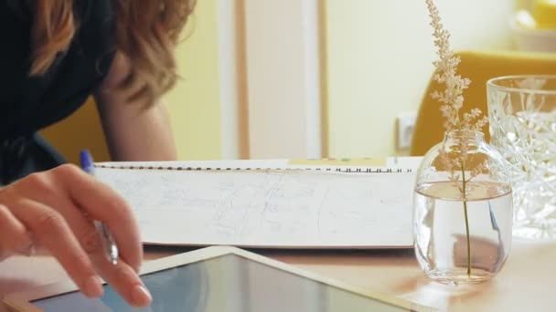 Business woman sitting at a table in a cafe drinking coffee and working on a tablet — Stock Video