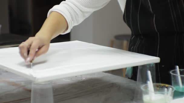 Женщины в художественной студии смешивают краски и рисуют на холсте в технике жидкого искусства — стоковое видео