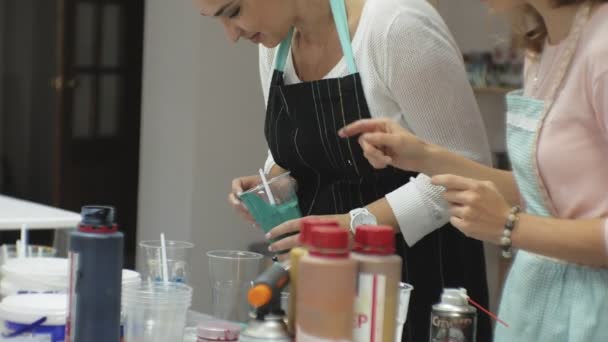 Mujeres en un estudio de arte mezclar pinturas y dibujar sobre lienzo en técnica de arte fluido — Vídeos de Stock