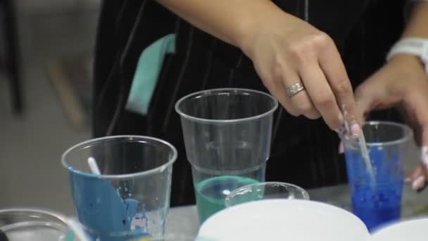Bir sanat stüdyosu kadınlarda boyalar mix ve tuval sanat sıvı tekniği üzerine çizmek — Stok video