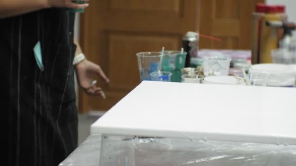 Mujeres en un estudio de arte mezclar pinturas y dibujar sobre lienzo en técnica de arte fluido — Vídeo de stock