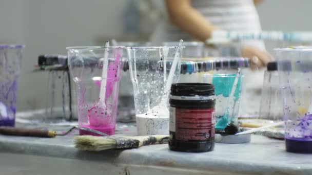 Kvinnor i en konststudio blanda färger och rita på canvas i vätska art teknik — Stockvideo