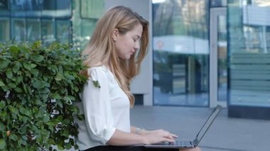 Şehir park iş merkezi içinde laptop üzerinde çalışan genç iş kadını