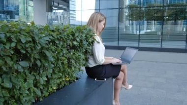Şehir park iş merkezi içinde laptop üzerinde çalışan genç iş kadını