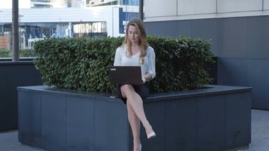 Şehir park iş merkezi içinde laptop üzerinde çalışan genç iş kadını
