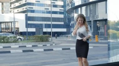 Genç iş kadını konuşmak smartphone şehir park iş merkezinde kullanıyor