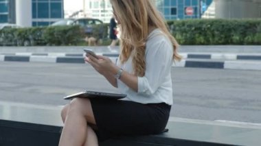 Genç iş kadını konuşmak smartphone şehir park iş merkezinde kullanıyor