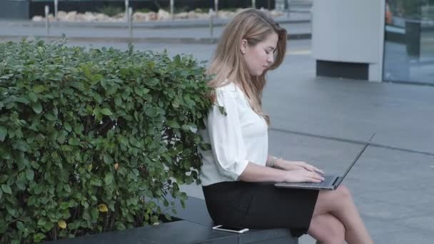Young businesswoman working on laptop in city park business center — Stock Video