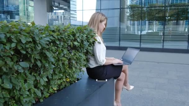 Jovem empresária trabalhando no laptop no centro de negócios do parque da cidade — Vídeo de Stock