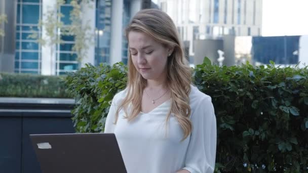 Jeune femme d'affaires travaillant sur ordinateur portable dans le centre d'affaires du parc de la ville — Video