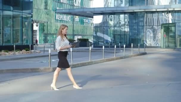 Joven mujer de negocios está paseando en el centro de negocios del parque de la ciudad — Vídeo de stock