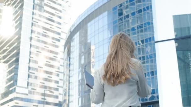 Joven mujer de negocios hablando está utilizando el teléfono inteligente en el centro de negocios del parque de la ciudad — Vídeos de Stock