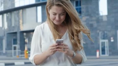 Genç iş kadını konuşmak smartphone şehir park iş merkezinde kullanıyor