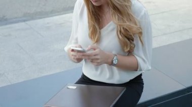Genç iş kadını konuşmak smartphone şehir park iş merkezinde kullanıyor