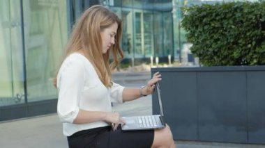Şehir park iş merkezi içinde laptop üzerinde çalışan genç iş kadını