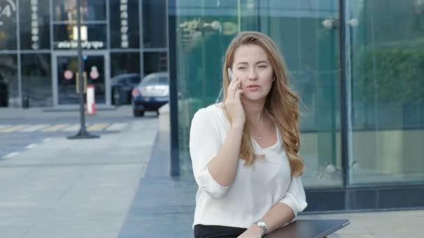 Молода ділова жінка говорить за допомогою смартфона в діловому центрі міського парку — стокове відео