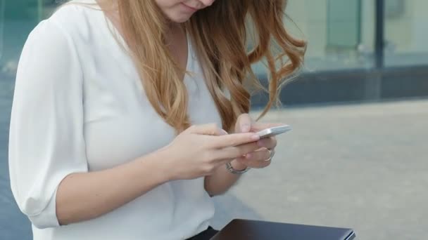 Jovem mulher de negócios falando está usando smartphone no centro de negócios do parque da cidade — Vídeo de Stock