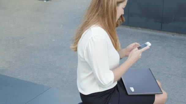 Young business woman talking is using smartphone in city park business center — Stock Video