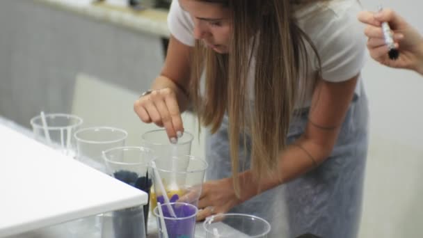 Donne in uno studio d'arte mescolare vernici e disegnare su tela in tecnica di arte fluida — Video Stock