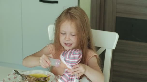 Gelukkig mooi meisje eten van pap voor het ontbijt en het plezier in witte keuken thuis — Stockvideo