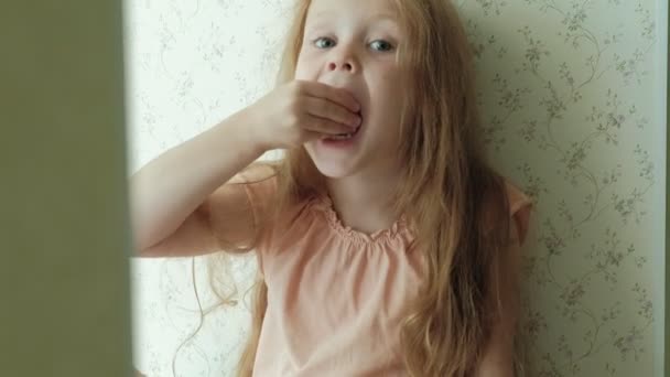 Τρώγοντας ένα καρπούζι το καλοκαίρι στην κουζίνα στο σπίτι το μικρό κορίτσι — Αρχείο Βίντεο