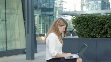 Şehir park iş merkezi içinde laptop üzerinde çalışan genç iş kadını