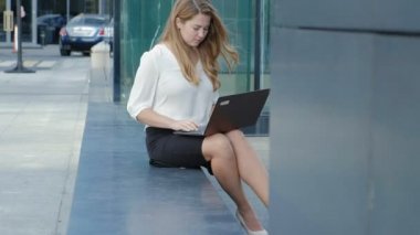Şehir park iş merkezi içinde laptop üzerinde çalışan genç iş kadını