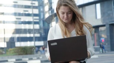 Şehir park iş merkezi içinde laptop üzerinde çalışan genç iş kadını