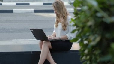 Şehir park iş merkezi içinde laptop üzerinde çalışan genç iş kadını