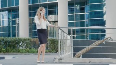 Genç iş kadını konuşmak smartphone şehir park iş merkezinde kullanıyor