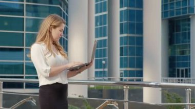 Şehir park iş merkezi 4 k içinde laptop üzerinde çalışan genç iş kadını