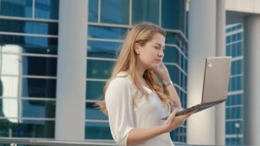 Şehir park iş merkezi içinde laptop üzerinde çalışan genç iş kadını